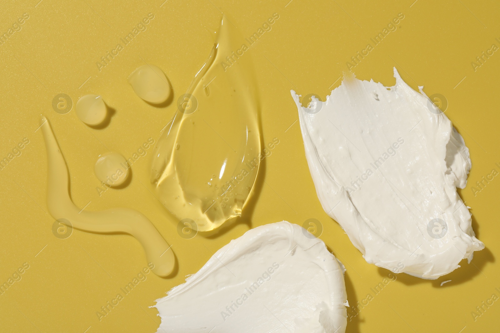 Photo of Samples of different cosmetic products on yellow background, flat lay