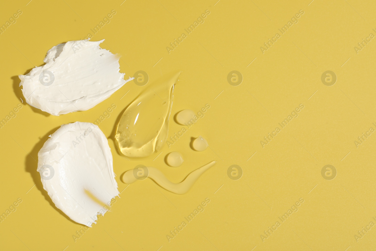 Photo of Samples of different cosmetic products on yellow background, flat lay. Space for text