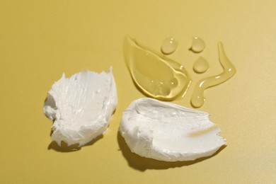 Photo of Samples of different cosmetic products on yellow background, closeup