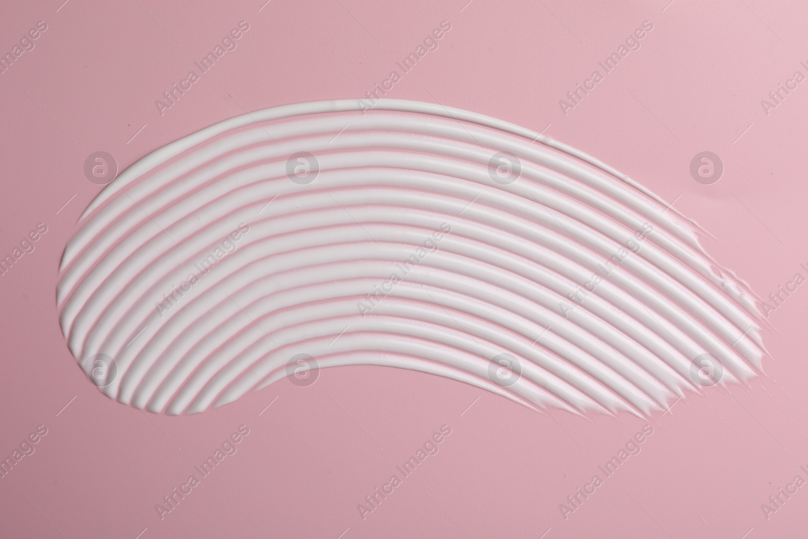 Photo of Cream on pink background, top view. Sample of cosmetic product