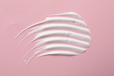 Photo of Cream on pink background, top view. Sample of cosmetic product