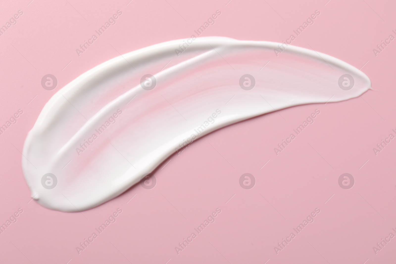 Photo of Cream on pink background, top view. Sample of cosmetic product