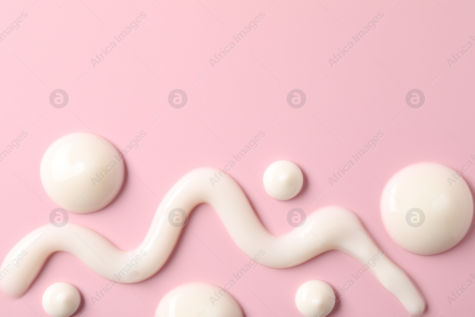 Photo of Cream on pink background, flat lay and space for text. Samples of cosmetic product