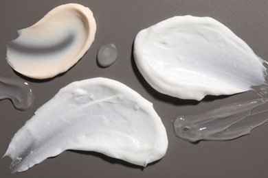 Samples of different cosmetic products on grey background, flat lay