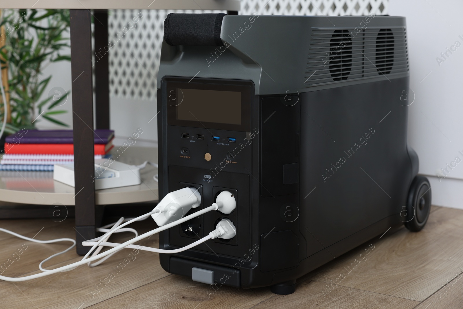 Photo of Modern portable power station, charging attached devices indoors