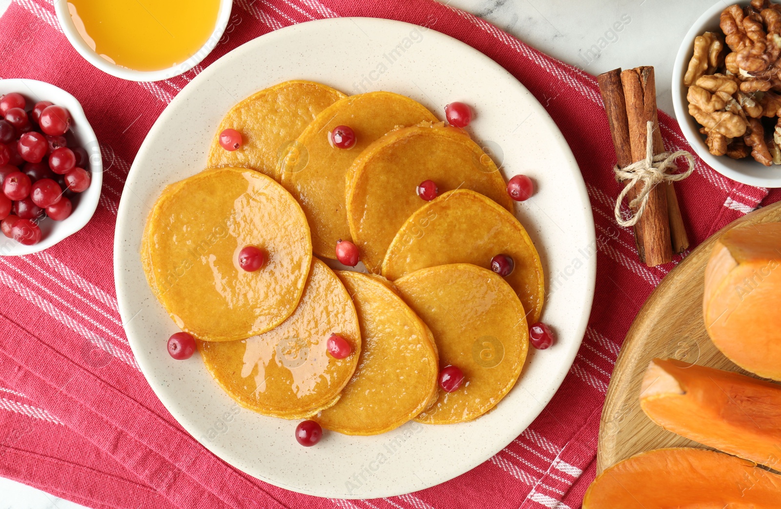 Photo of Tasty pumpkin pancakes served on white marble table, flat lay