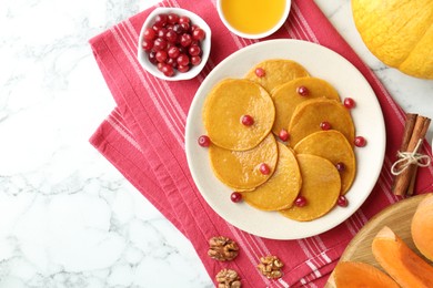 Photo of Tasty pumpkin pancakes served on white marble table, flat lay. Space for text