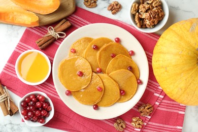 Photo of Tasty pumpkin pancakes served on white marble table, flat lay