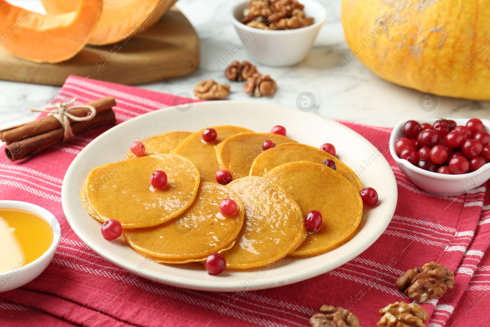 Photo of Tasty pumpkin pancakes served on white table