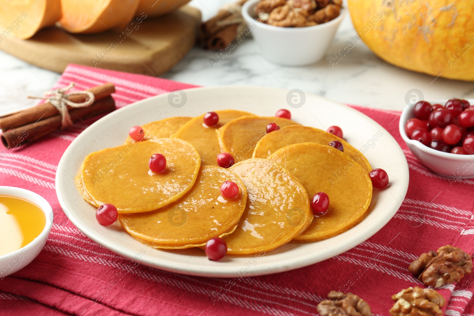 Photo of Tasty pumpkin pancakes served on white table