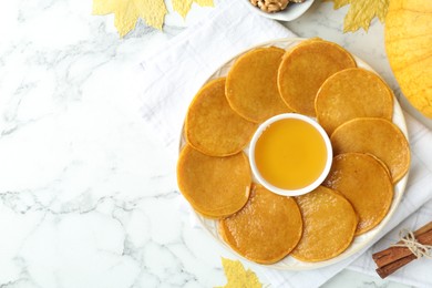 Photo of Tasty pumpkin pancakes served on white marble table, flat lay. Space for text