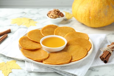 Photo of Tasty pumpkin pancakes on white marble table, closeup