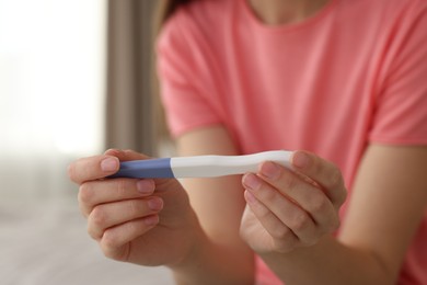 Photo of Woman with negative pregnancy test at home, closeup