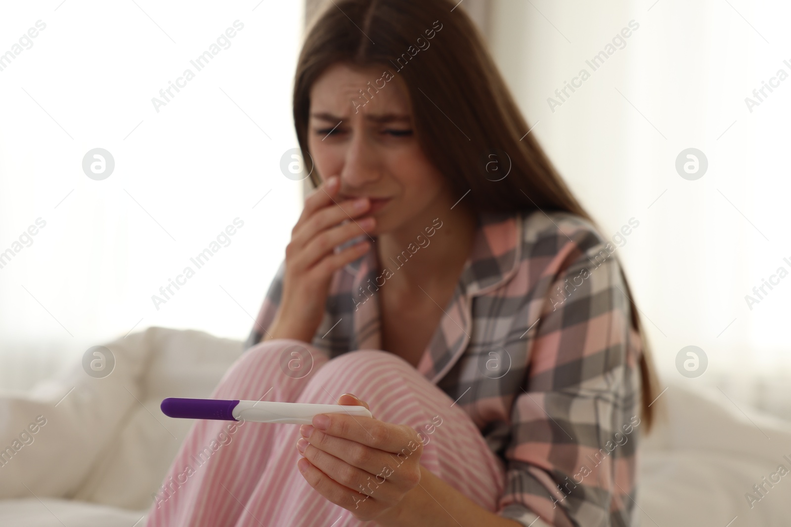 Photo of Woman with negative pregnancy test at home, selective focus