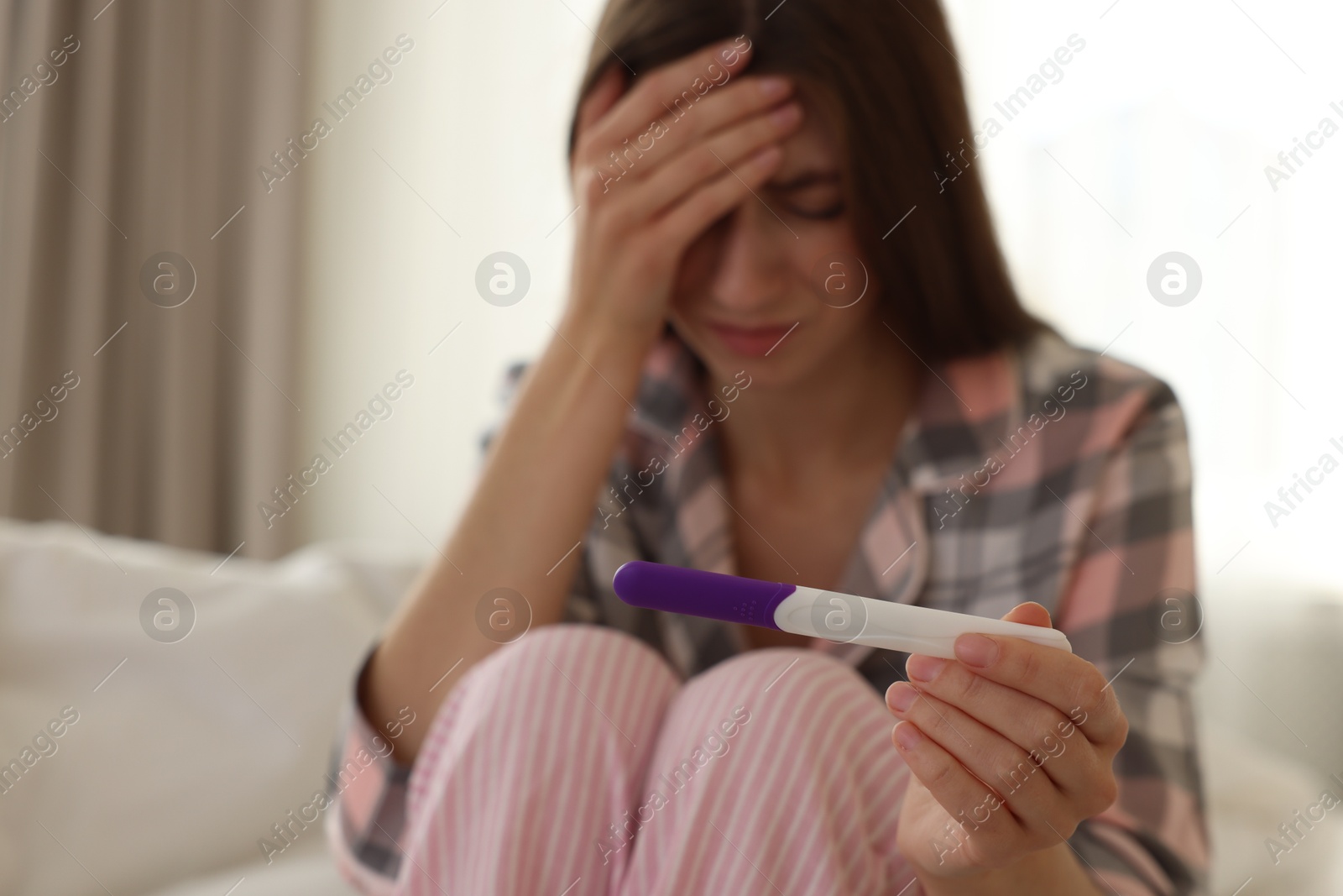 Photo of Woman with negative pregnancy test at home, selective focus