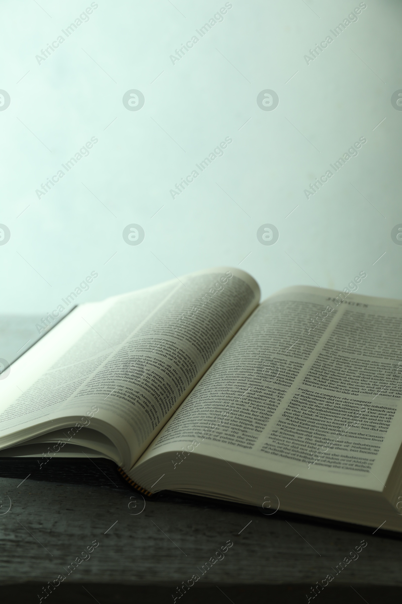 Photo of Open Holy Bible in English language on wooden table, closeup. Space for text