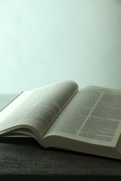 Photo of Open Holy Bible in English language on wooden table, closeup. Space for text