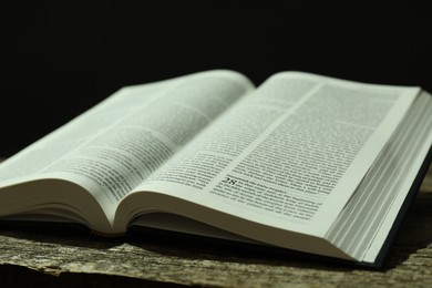 Open Holy Bible in English language on wooden table, closeup