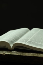 Open Holy Bible in English language on wooden table, closeup