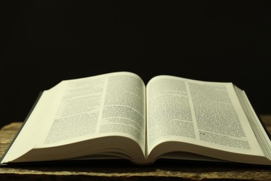 Photo of Open Holy Bible in English language on wooden table, closeup. Space for text