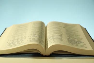 Photo of Open Holy Bible in English language on white table, closeup