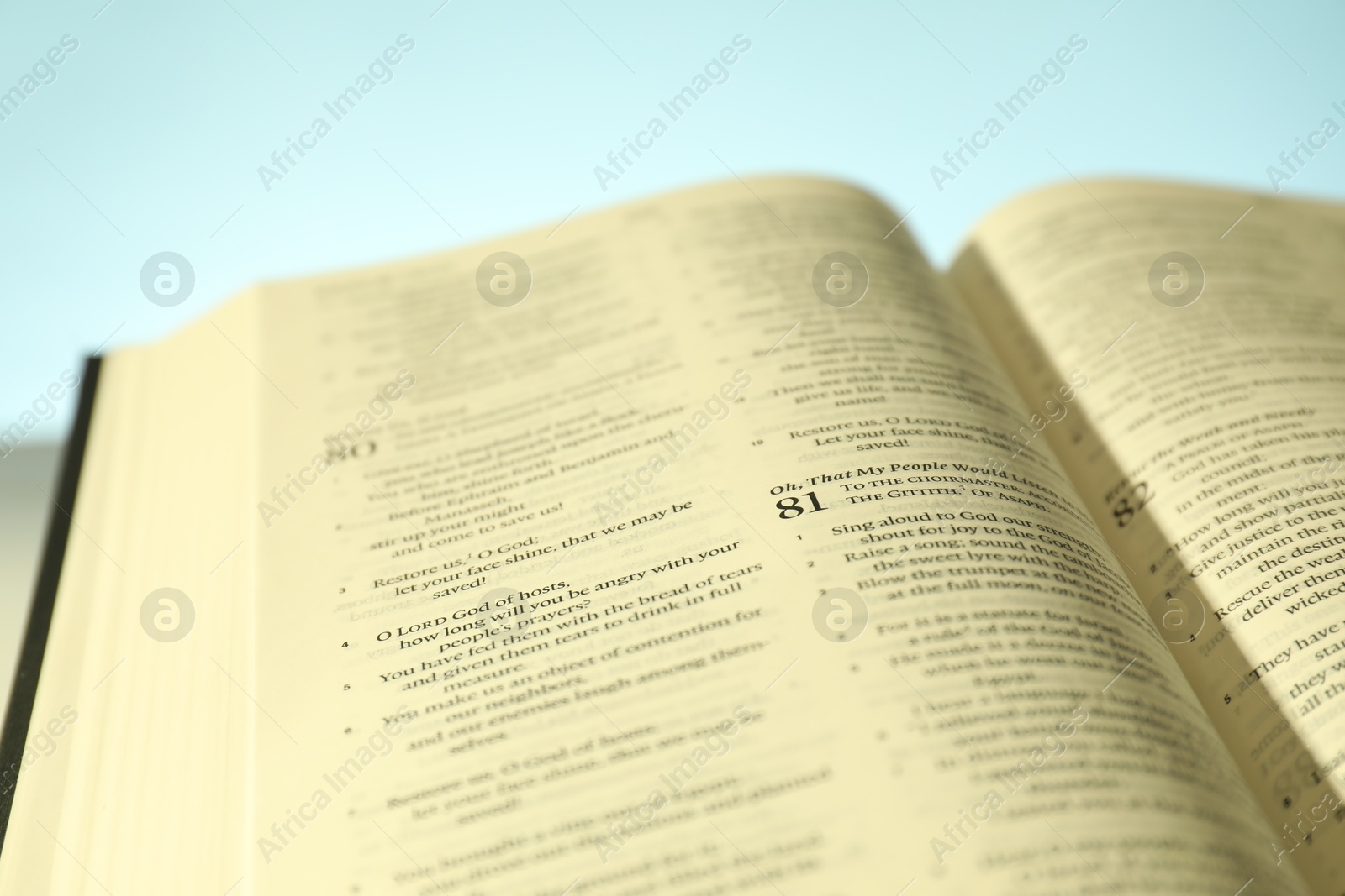 Photo of Open Holy Bible in English language on table, closeup