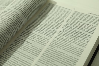 Open Holy Bible in English language on table, closeup