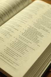 Open Holy Bible in English language on wooden table, closeup