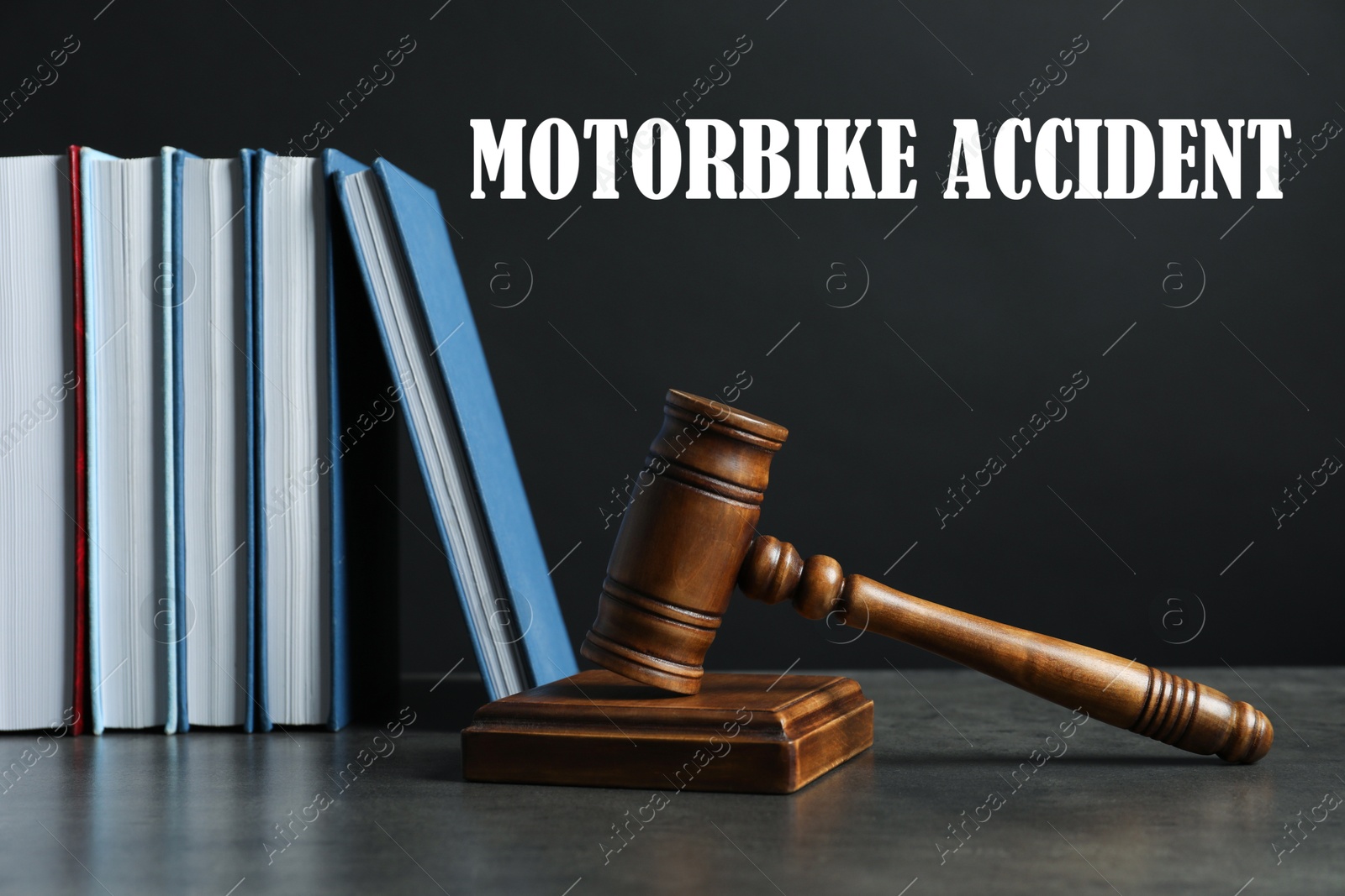 Image of Motorbike accident law. Judge's gavel and books on table against dark background