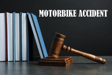 Image of Motorbike accident law. Judge's gavel and books on table against dark background