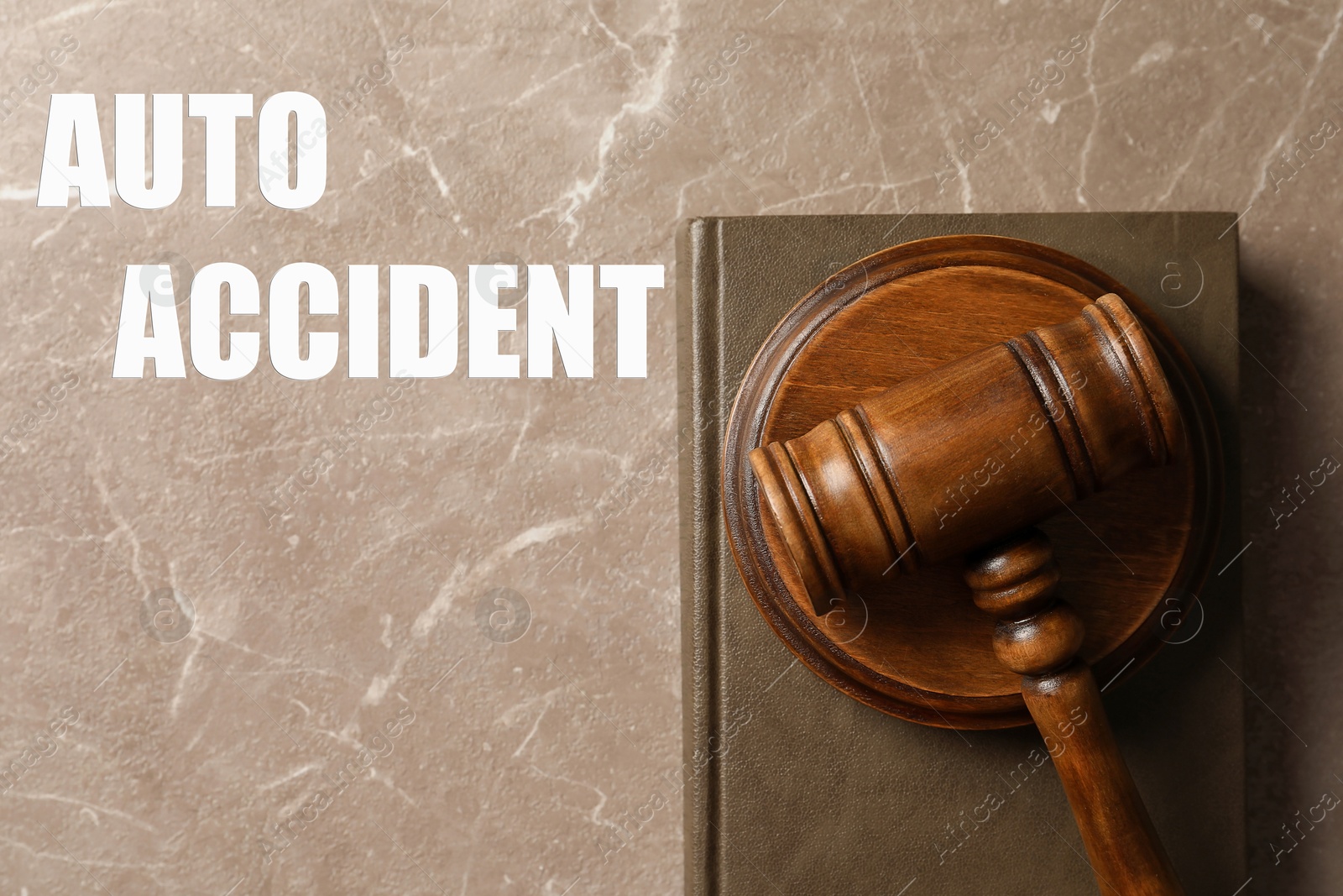 Image of Auto accident law. Wooden judge's gavel and book on marble table, top view