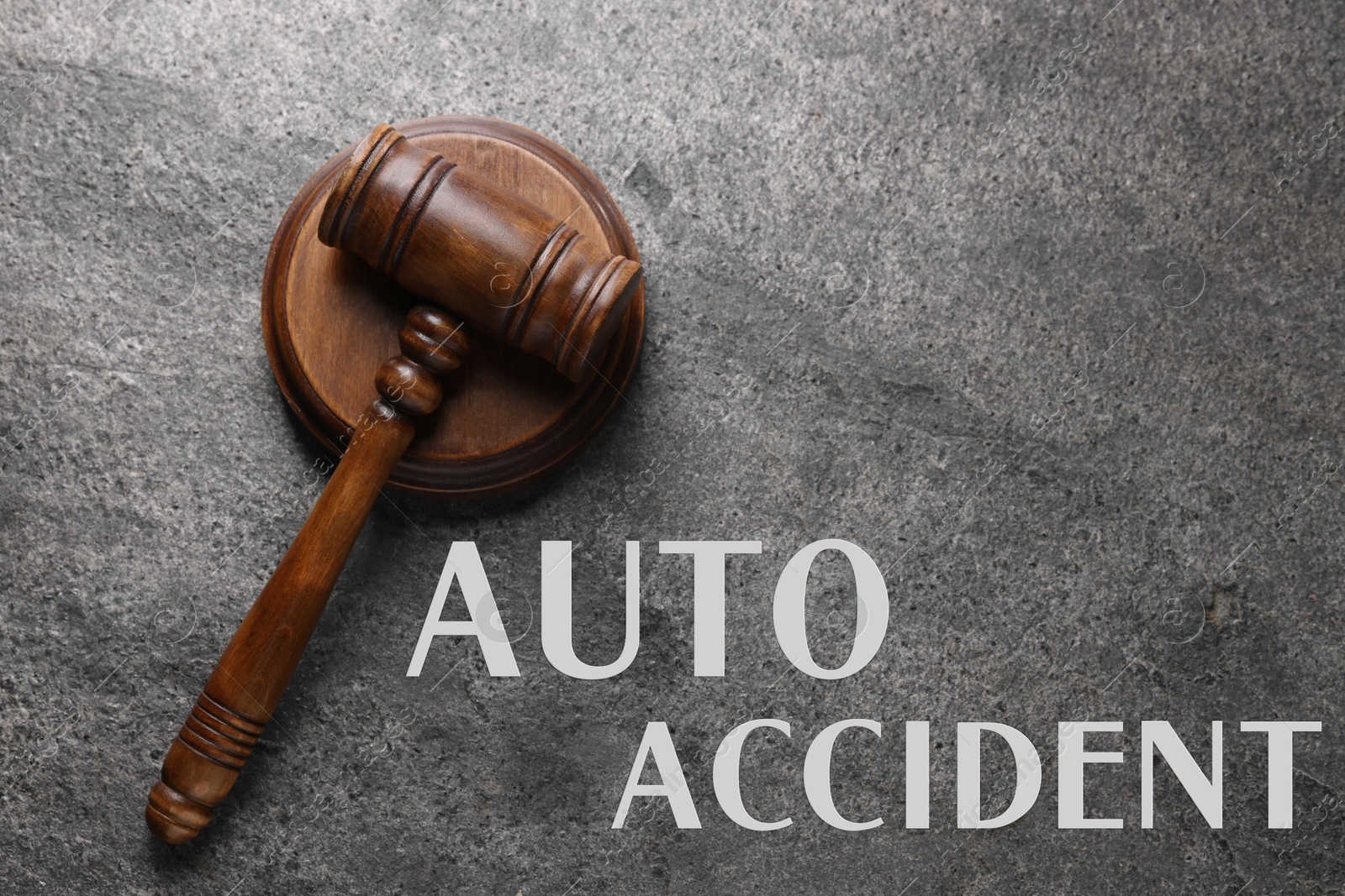 Image of Auto accident law. Judge's gavel on grey table, top view