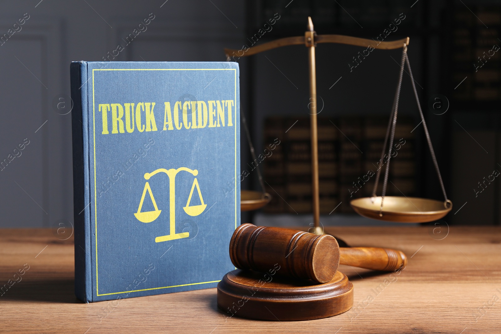 Image of Truck Accident law book, judge's gavel and scales on wooden table