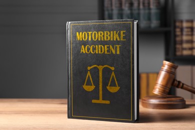 Image of Motorbike Accident law book and judge's gavel on wooden table, space for text