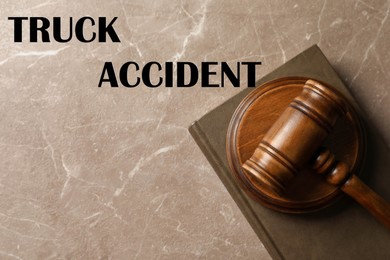 Image of Truck accident law. Wooden judge's gavel and book on marble table, top view