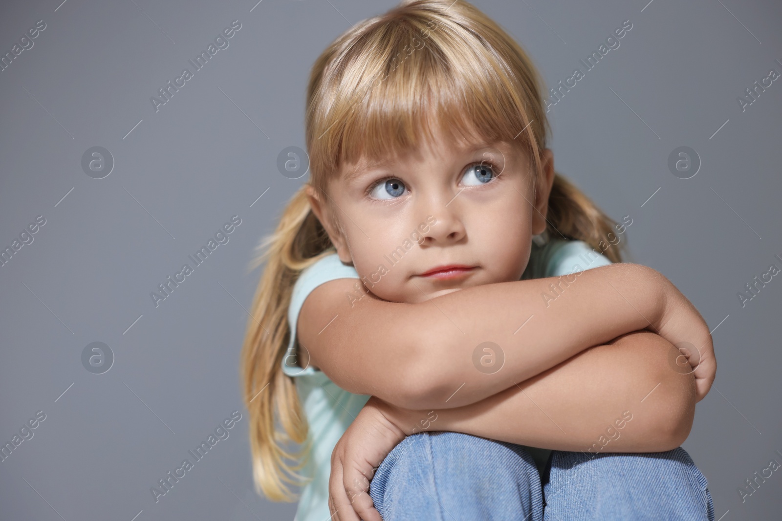 Photo of Orphanage concept. Sad little girl on grey background