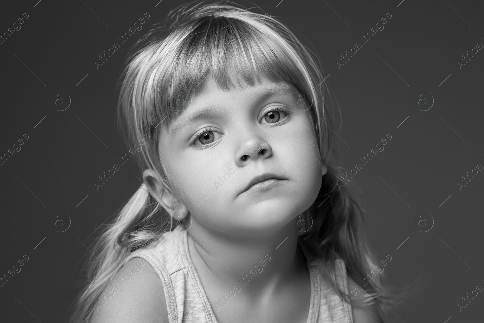 Photo of Orphanage concept. Sad little girl on dark background. Black and white effect