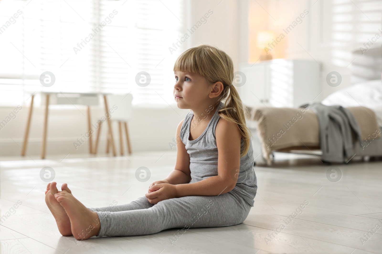 Photo of Orphanage concept. Sad little girl on floor indoors