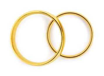 Photo of Beautiful golden wedding rings isolated on white, top view