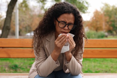 Photo of Young woman with runny nose in park