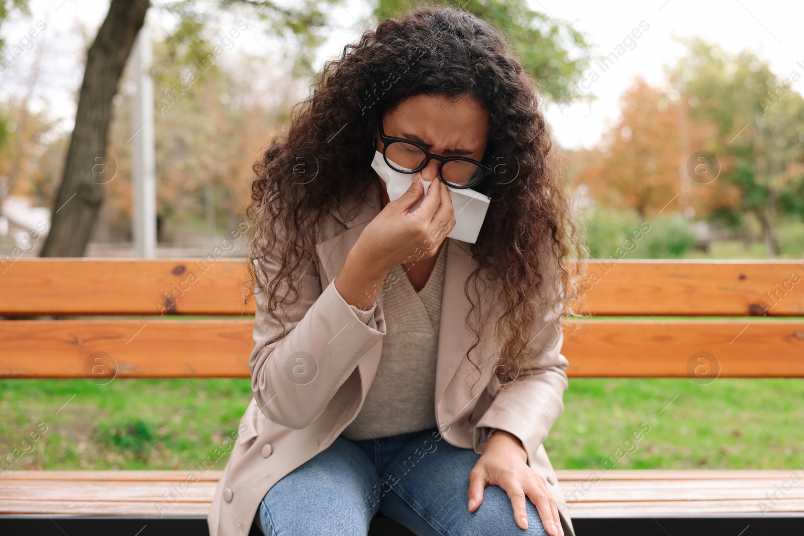 Photo of Young woman with runny nose in park