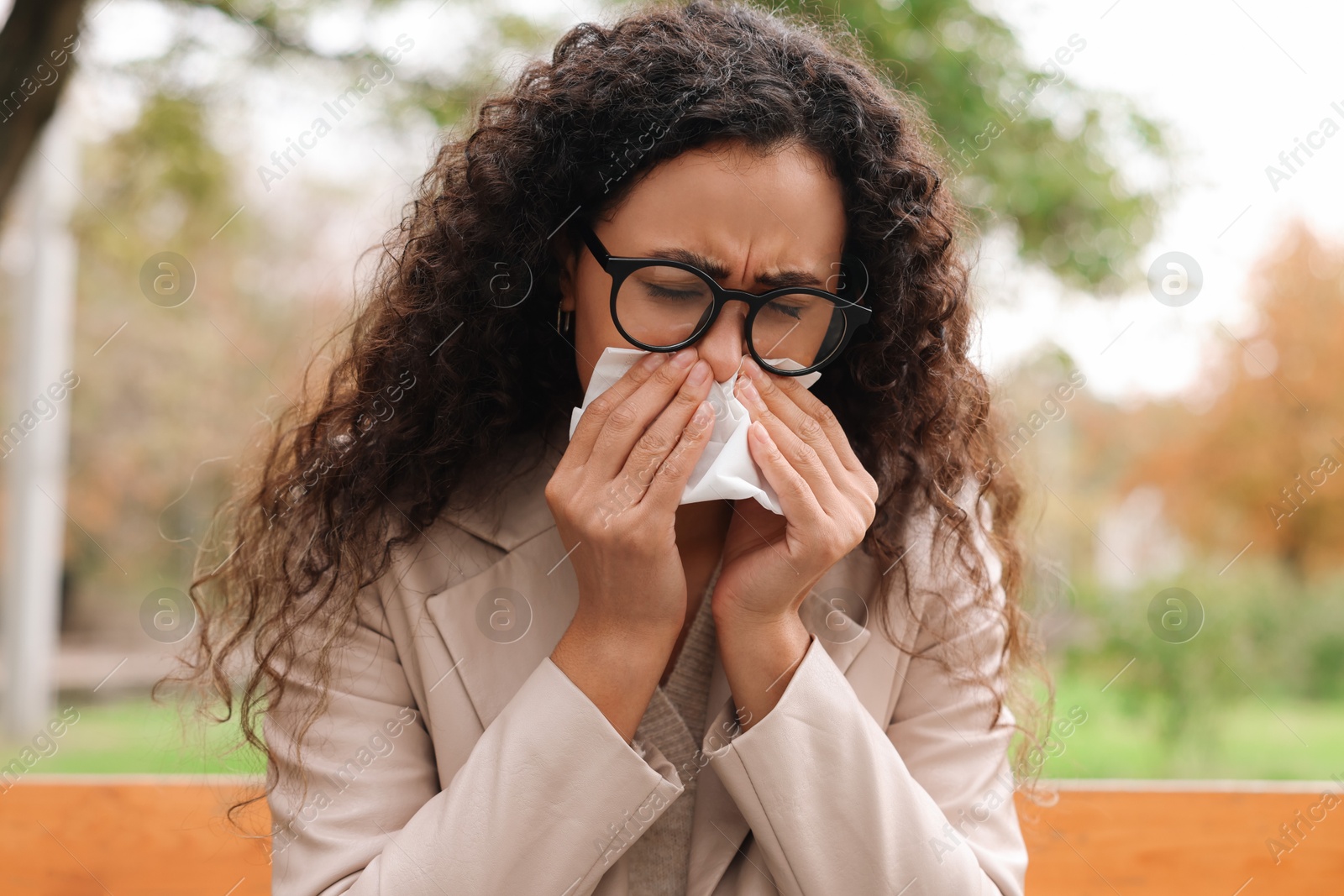 Photo of Young woman with runny nose in park