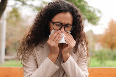 Photo of Young woman with runny nose in park