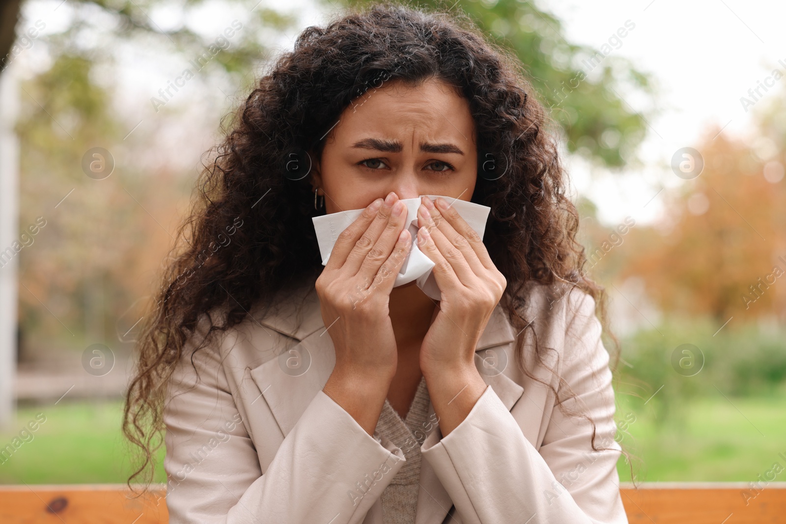 Photo of Young woman with runny nose in park