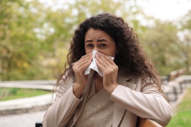 Photo of Young woman with runny nose in park