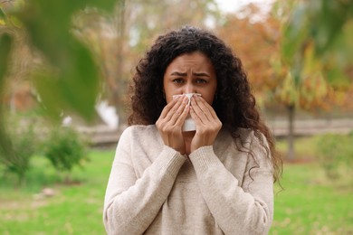 Photo of Young woman with runny nose in park