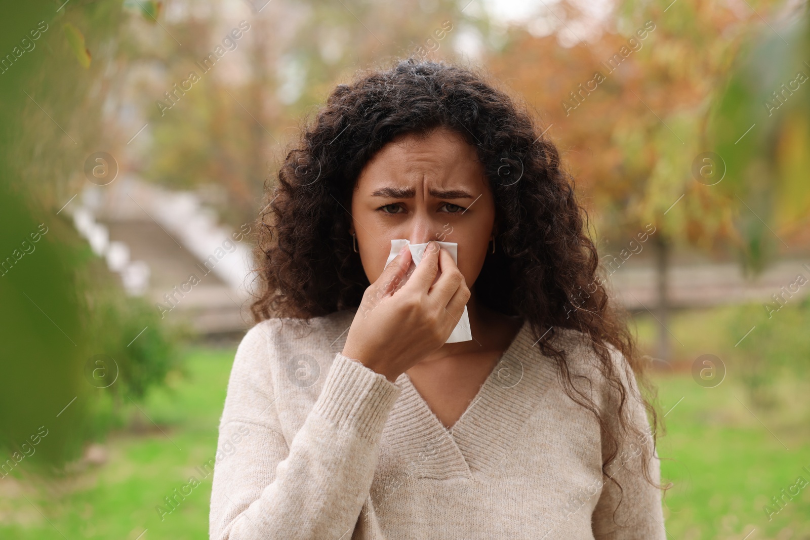 Photo of Young woman with runny nose in park