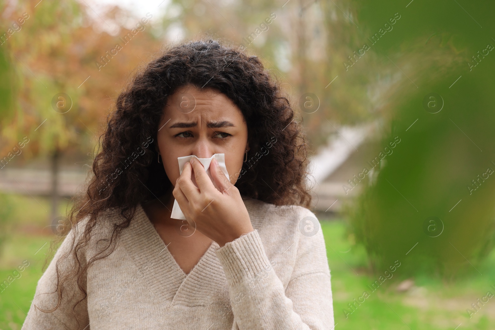 Photo of Young woman with runny nose in park