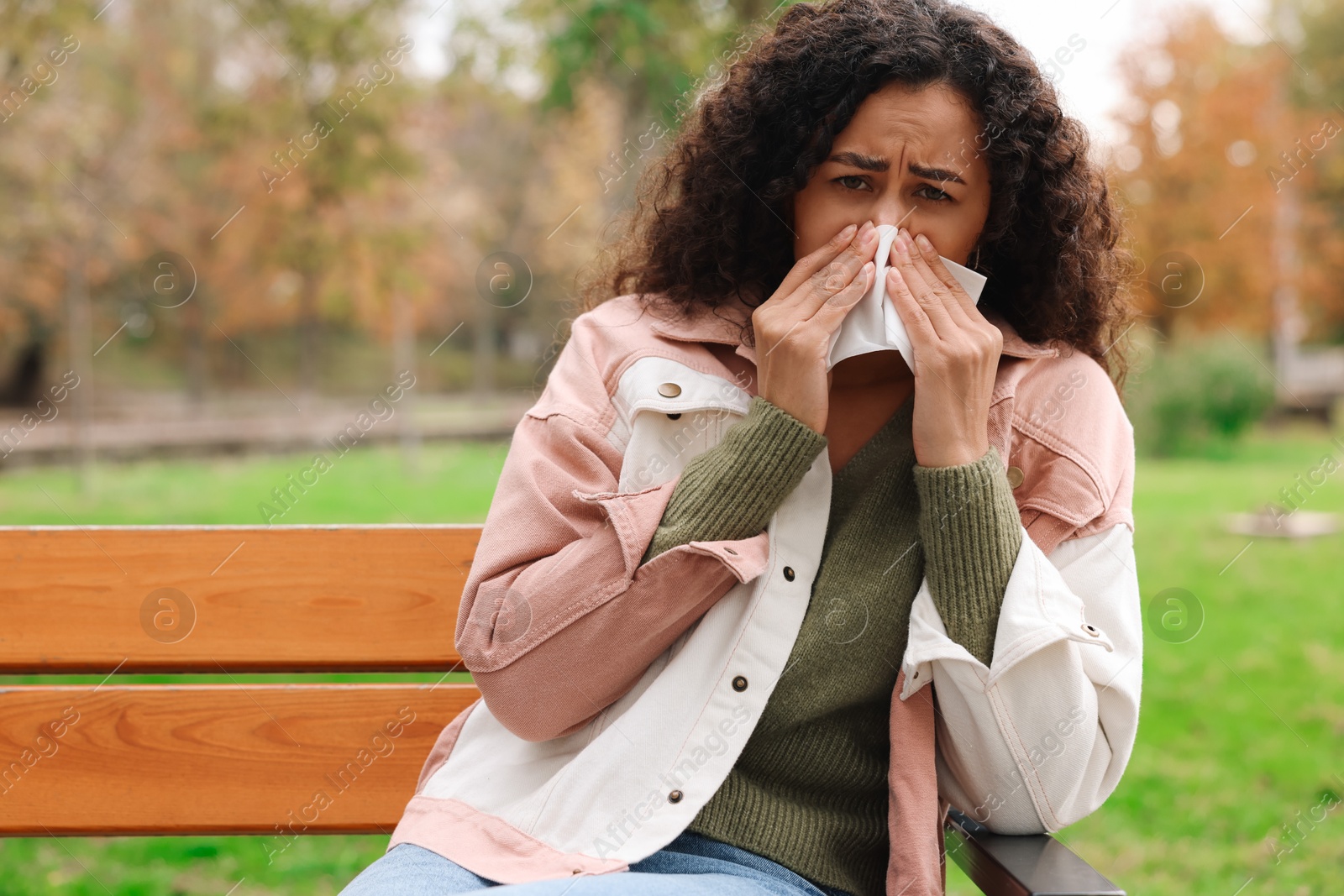 Photo of Young woman with runny nose in park