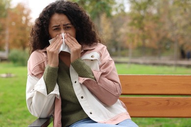 Photo of Young woman with runny nose in park